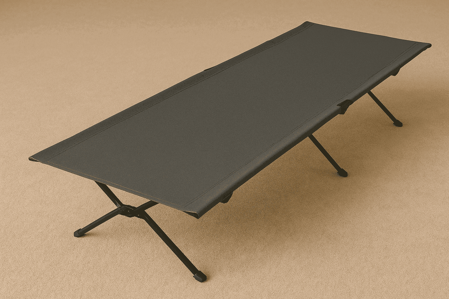 A photograph features a full-length, portable camping cot with a black metal frame and taut dark gray fabric surface, positioned on a beige textured background.