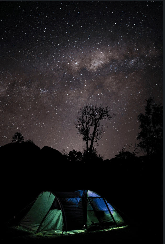 Tent under a starry night sky with the Milky Way galaxy.